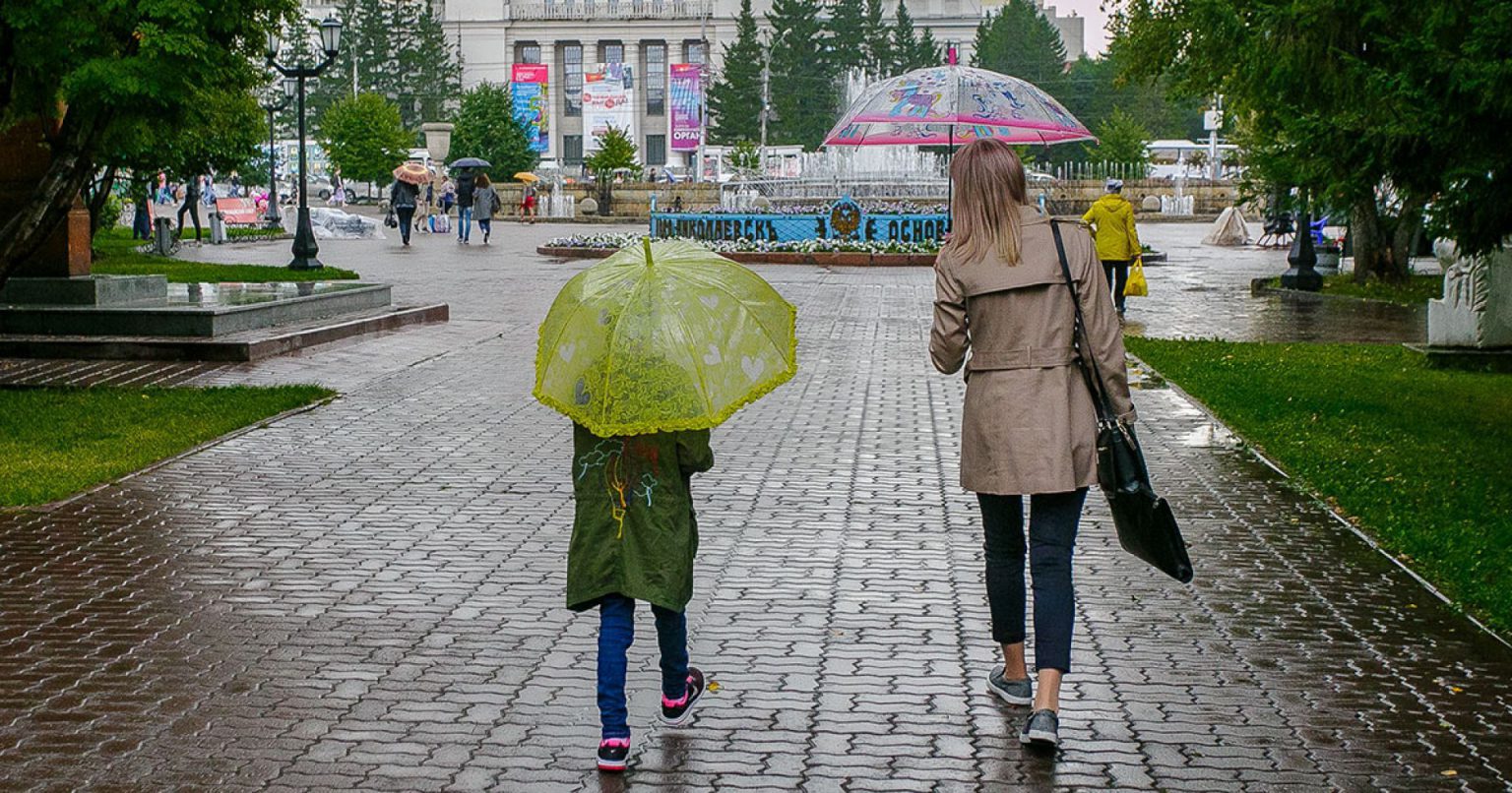 Не прекращавшийся в течение суток дождь. Человек из Новосиба шёл по улице весной. Жара погода НСО.